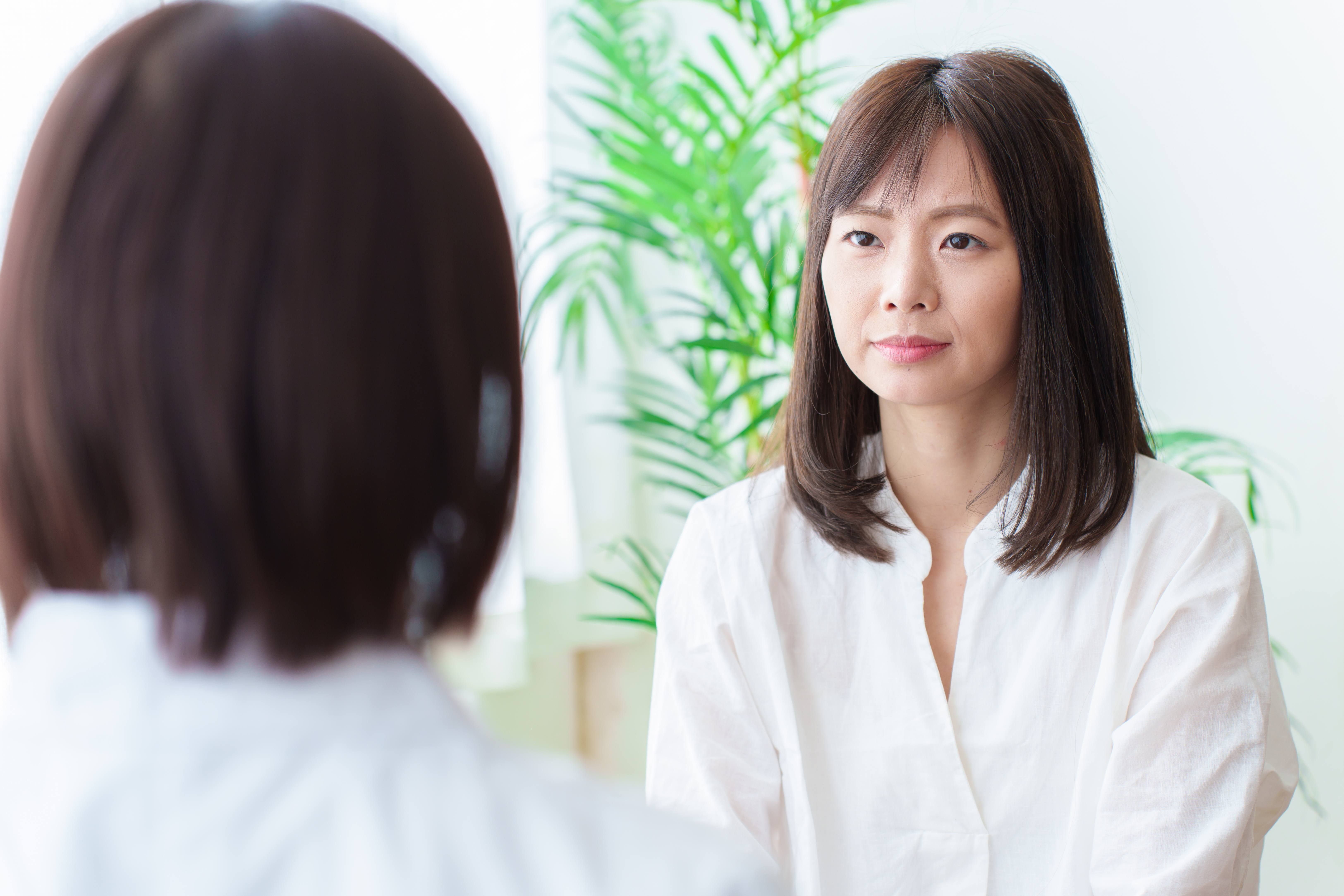 相談相手と向き合って話を聞いてもらう女性のイメージ